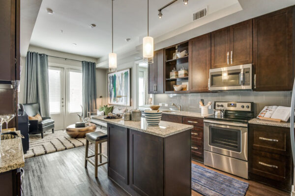 Modern, upscale kitchen and living room at The Kathryn apartments in Frisco, TX.
