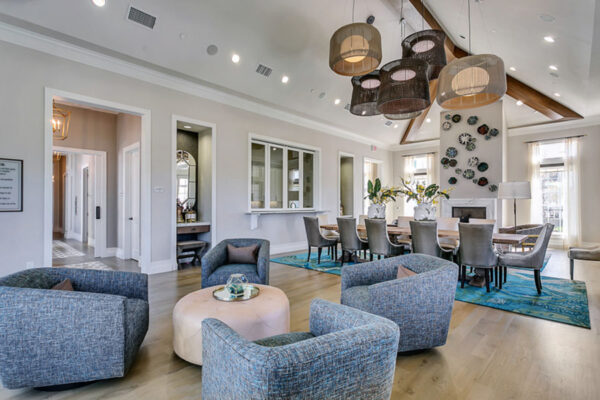 Lounge with wood floors, plush seating, large dining table, and fireplace.