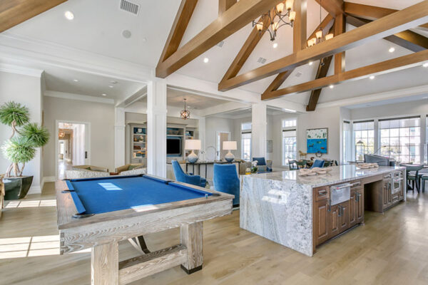 Community lounge with demo kitchen, pool table, and plush seating areas.