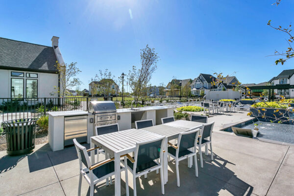 Pool area with built in BBQ grills and dining tables.