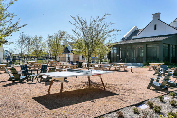 Outdoor game area with lounge chairs, picnic tables, and table tennis.