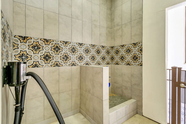 Dog wash area with tiles walls and floors and built in dryer.