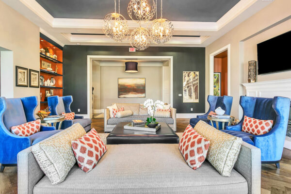 Clubroom with plush furniture, elegant decor, and large light fixtures.