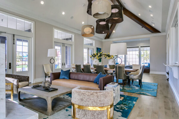 Lounge with wood floor, pattern rugs, plush seating, and large dining table.