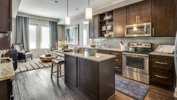 Modern, upscale kitchen and living room at The Kathryn apartments in Frisco, TX